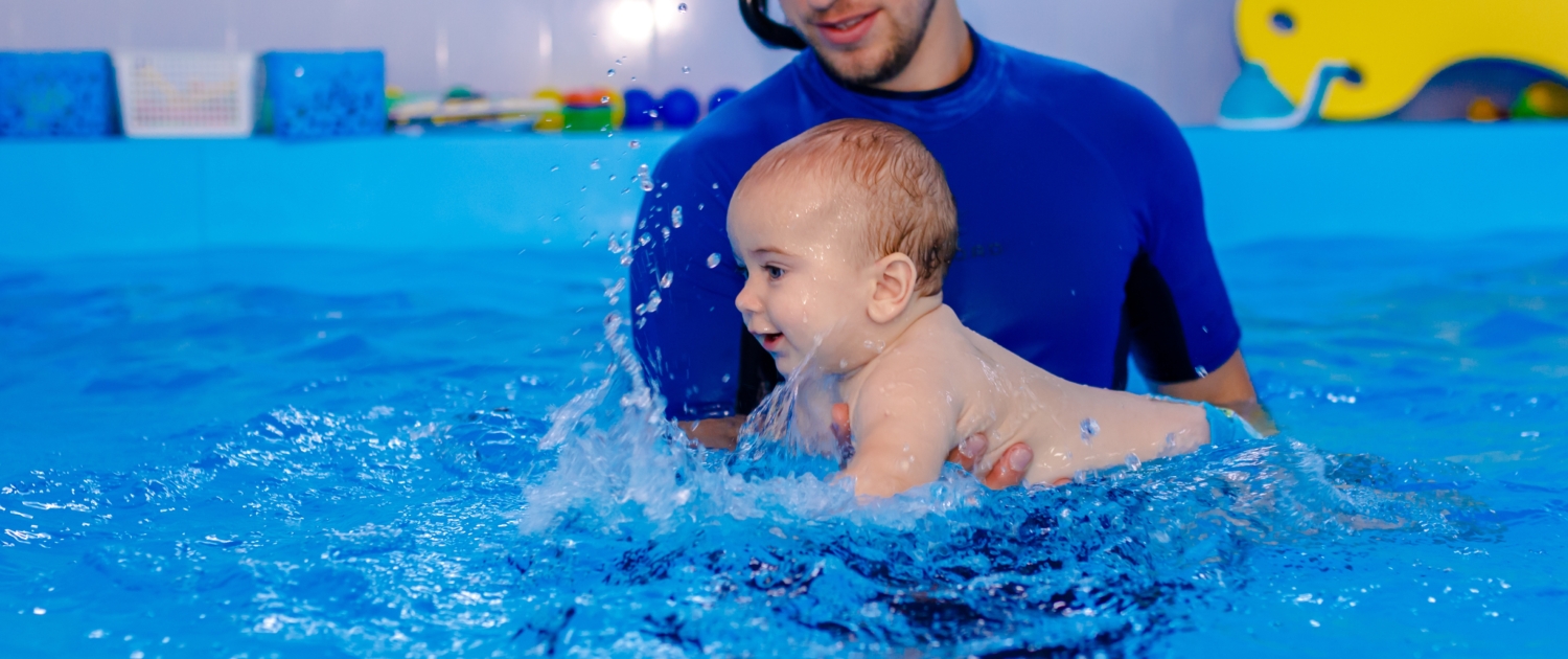 a-baby-swims-with-an-instructor-in-the-pool-the-c-2022-11-16-13-37-36-utc